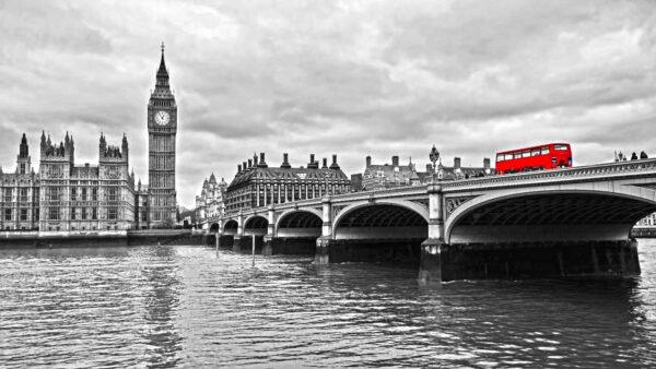 Bridge over water with a clock tower and a red bus