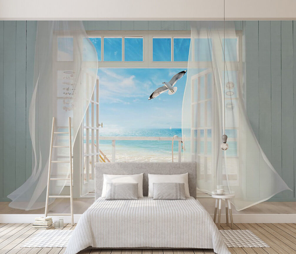 View of a beach from a room with a bird flying over it View of a beach from a room with a bird flying over it