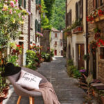 Fototapeta Úzká ulice s květinami a rostlinami po stranách