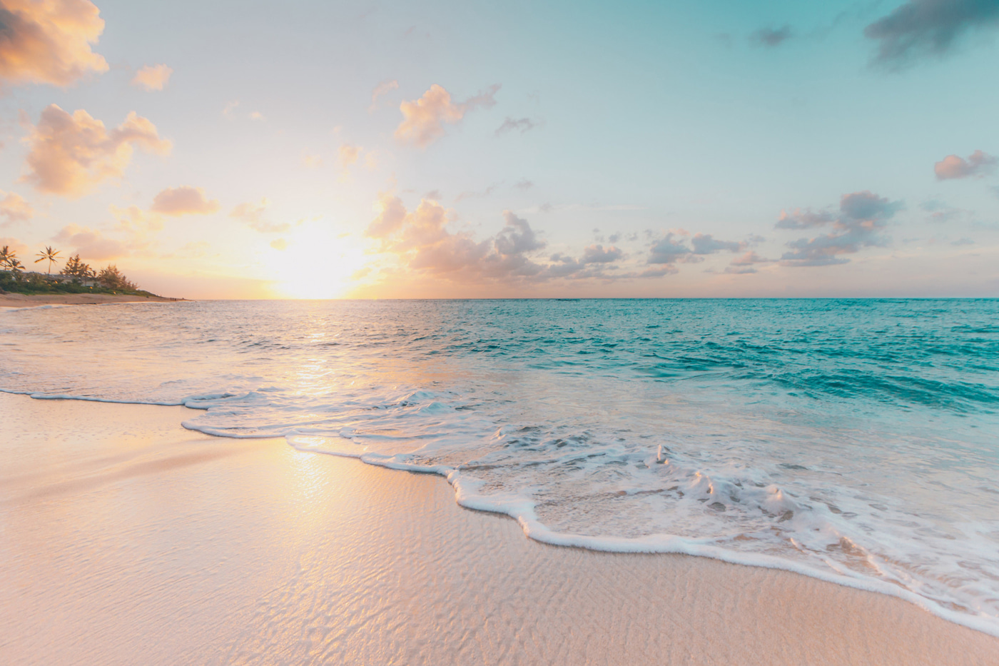 A beach with waves and a sunset