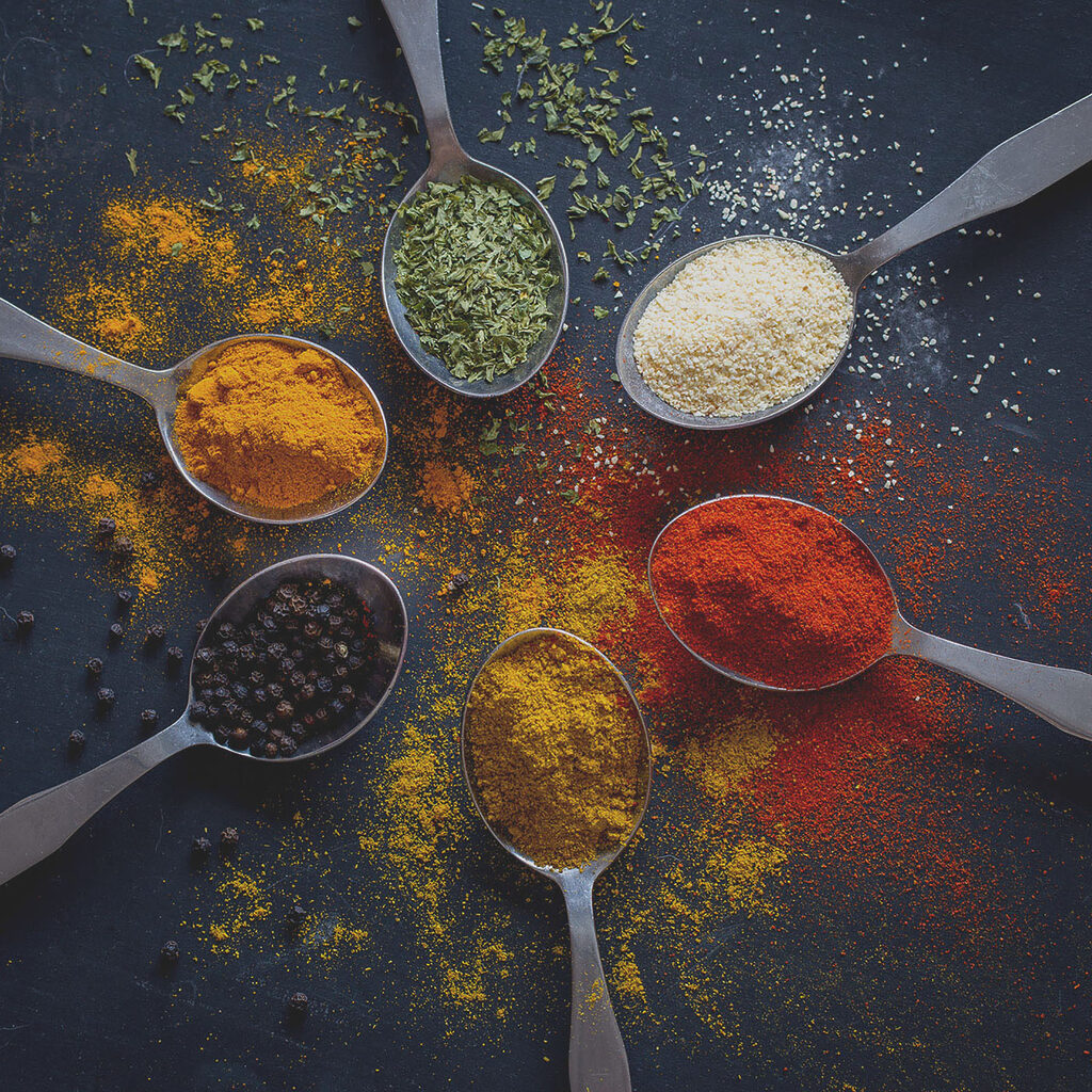 A group of spoons with different spices