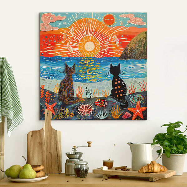 Two cats sitting on a beach looking at the sun