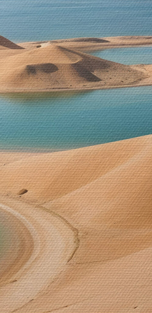 Desert with water and mountains in the background Desert with water and mountains in the background