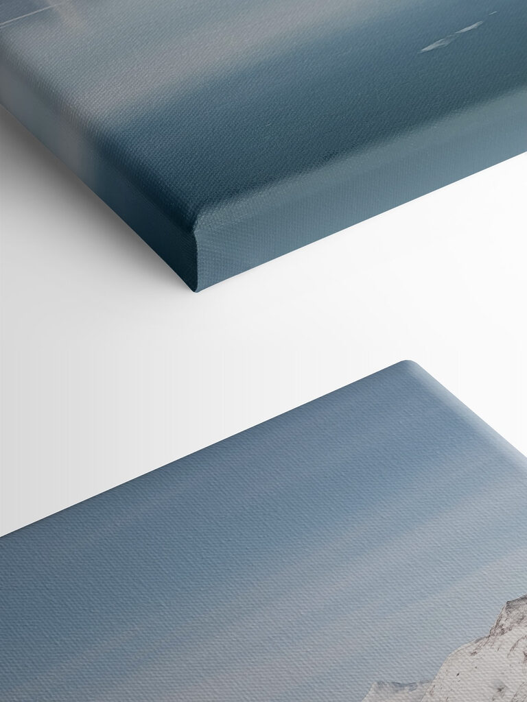 Red house on an island in water with snow covered mountains in the background